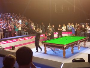 Picture of Ronnie OSullivan flashing his Champion of Champions trophy 2014 to the crowd